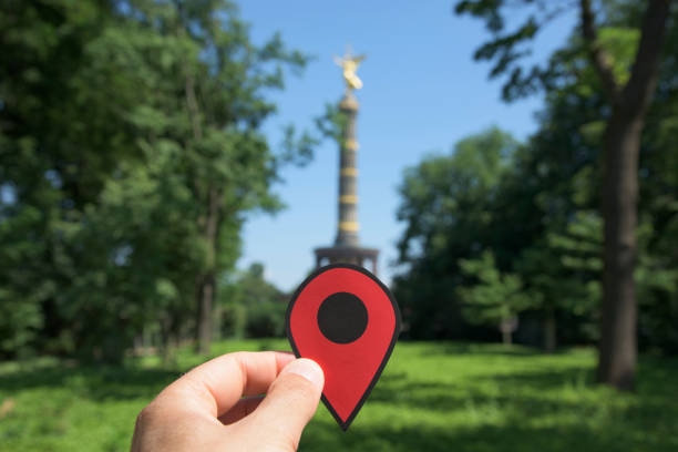 closeup of the hand of a young caucasian man with a red marker in the popular Victory Column in Berlin, Germany, seen from the Tiergarten park
