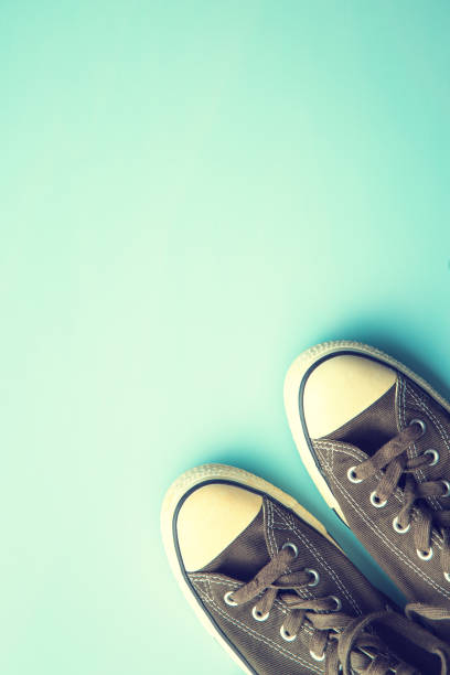 Warm sneakers, sporty shoes standing on cracked glass, colorful tonal correction, retro style photo filter