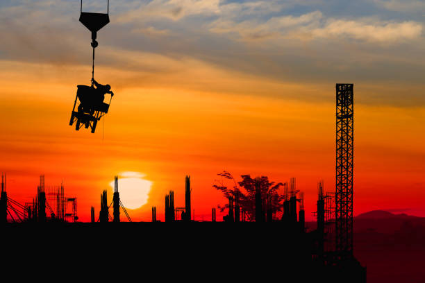 istock Silhouette construction  worker on crane hook on sunset-sunrise time background and copy space add text 966937282