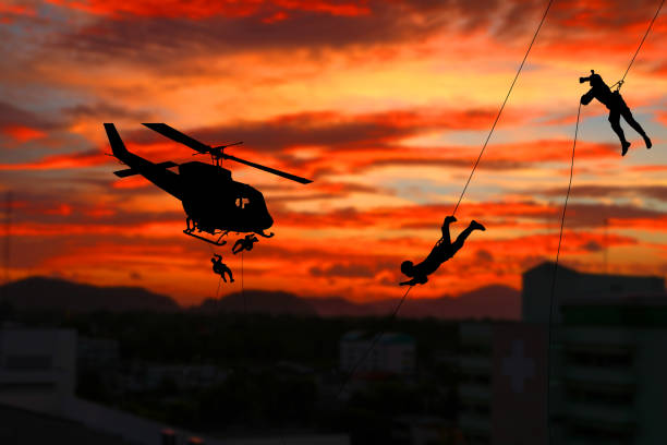 istock Silhouette Soldiers rappel down to attack from helicopter with sunset and copy space add text ( Concept stop hostilities To peace) 966937294