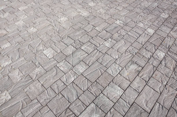 istock Stone pavement in perspective. Stone pavement texture. Granite cobblestoned pavement background. Abstract background of a cobblestone pavement close-up, house 966947586