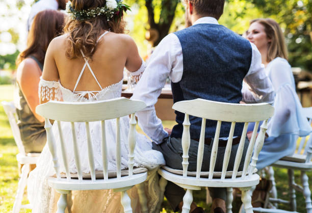 istock Bride and groom with guests at wedding reception outside in the backyard. 966952764