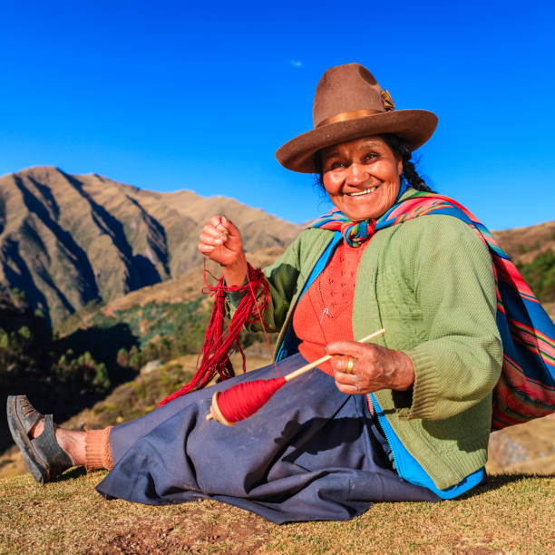 istock Peruvian woman spinning wool by hand, Sacred Valley, Peru 966953828
