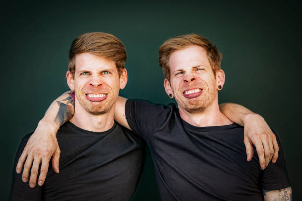 twin brothers making silly face grimace identical sibling brothers making silly face grimace, fun portrait. cloning photos stock pictures, royalty-free photos & images