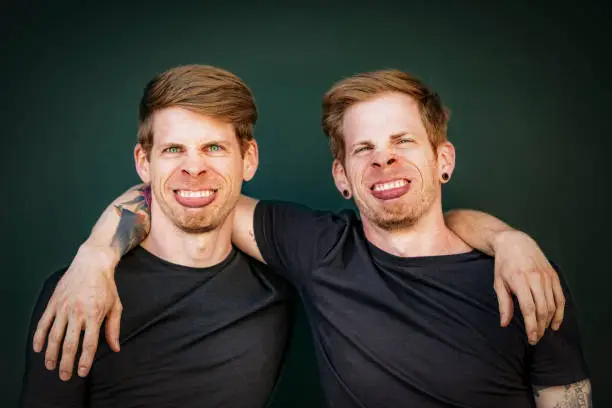 identical sibling brothers making silly face grimace, fun portrait.