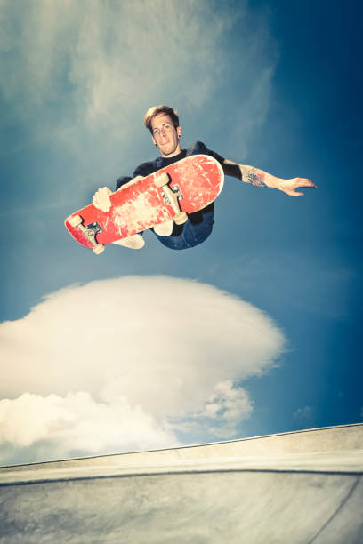 young extreme skateboarder practicing at the park young extreme skateboarder doing high aerial trick out of the bowl. Ollie stock pictures, royalty-free photos & images