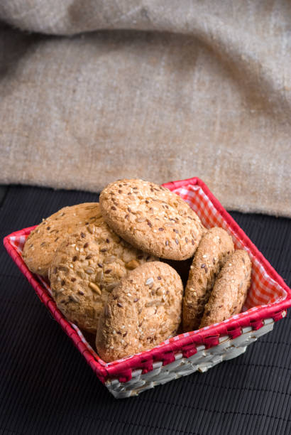 istock Savory cookies sprinkled with sesame seeds, sunflower on table and burlap background 966976900