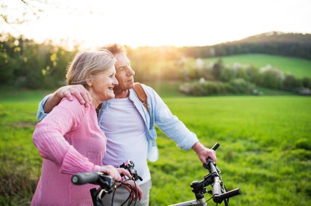 istock Beautiful senior couple with bicycles outside in spring nature. 966979558