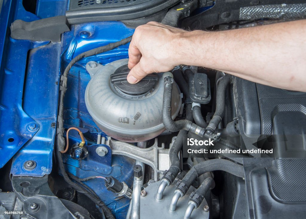 L’homme est l’ouverture réservoir fluide radiateur de voiture pour vérifier le niveau - Photo de Additif alimentaire libre de droits