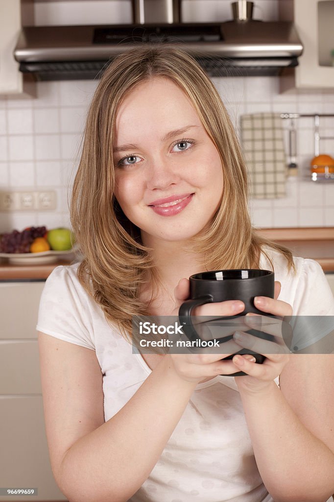 Felice donna con una tazza di caffè nelle sue mani - Foto stock royalty-free di Adulto