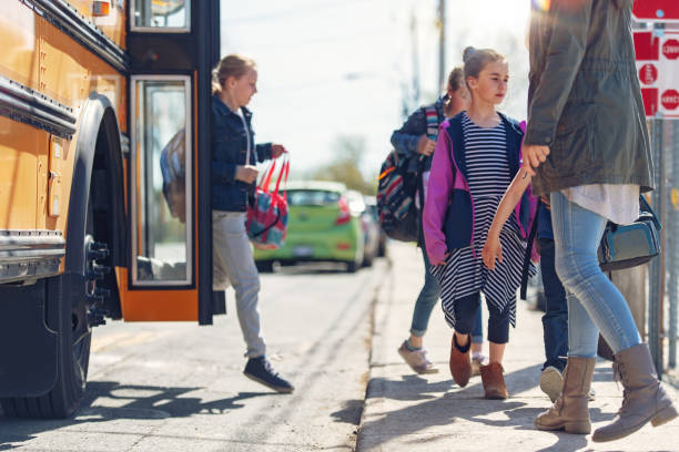 istock School kids getting out the school bus 967007004