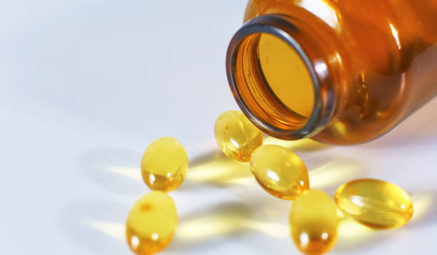 istock Colored pills poured from a brown bottle. Medical concept 967021138
