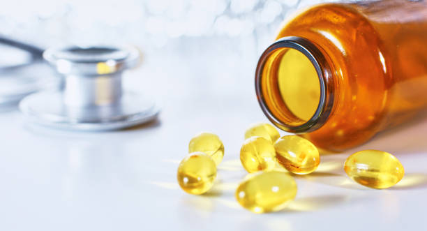 istock Colored pills poured from a brown bottle. Medical concept 967021638