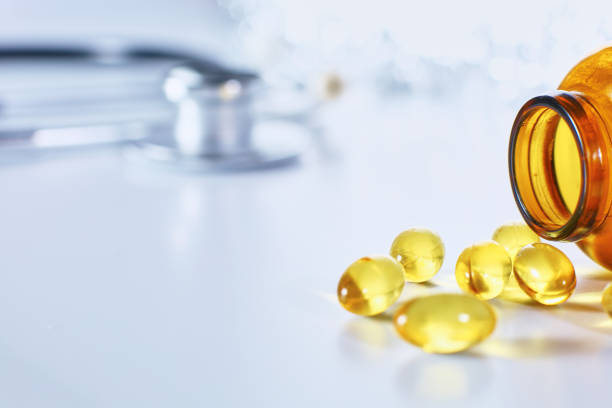 istock Colored pills poured from a brown bottle. Medical concept 967021824