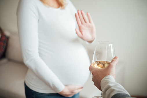Pregnant woman refusing to drink alcohol