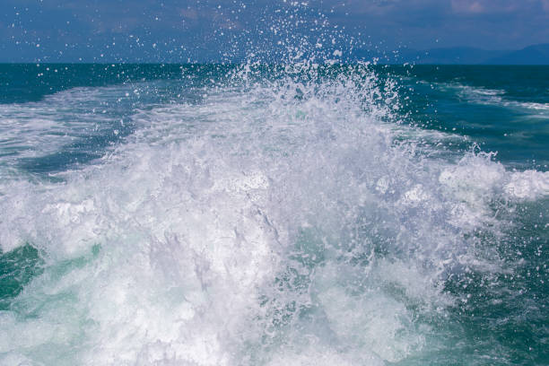 vague d’eau de mer océan bleu avec bateau yacht rapide wake mousse de lavage prop - prop wash photos et images de collection