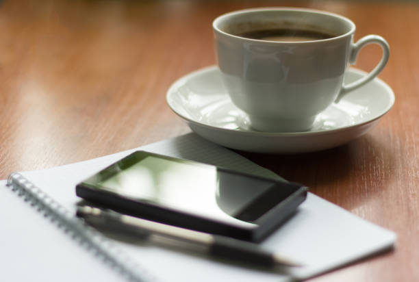 istock morning hot coffee, notebook and phone on the table 967031704