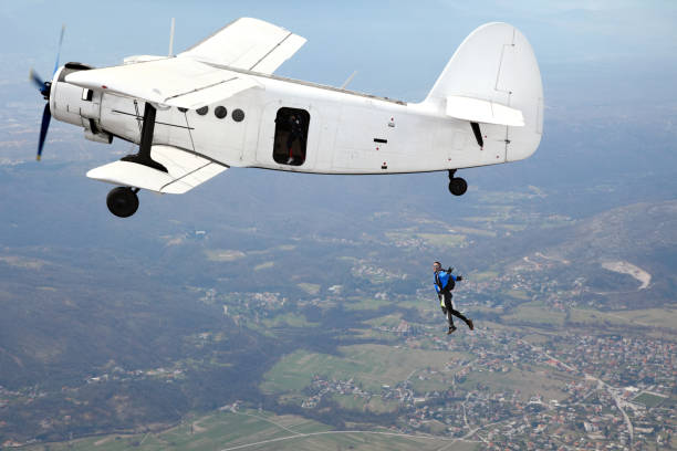 istock Parachutists jump from a vintage biplane 967046122