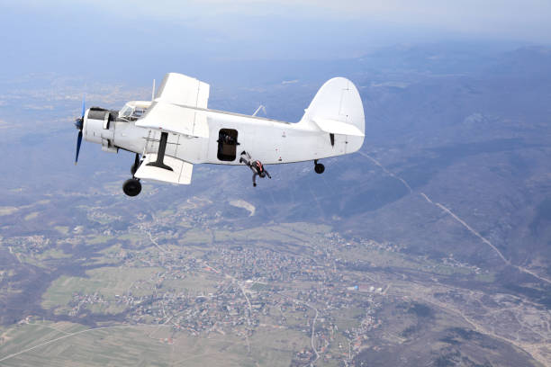 istock Parachutists jump from a vintage biplane 967046152