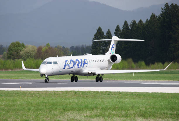 bombardier crj-900lr adria airways s5-aan - runway airport sky wet foto e immagini stock