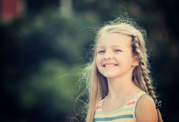 portrait of smiling girl standing outdoors on summer day