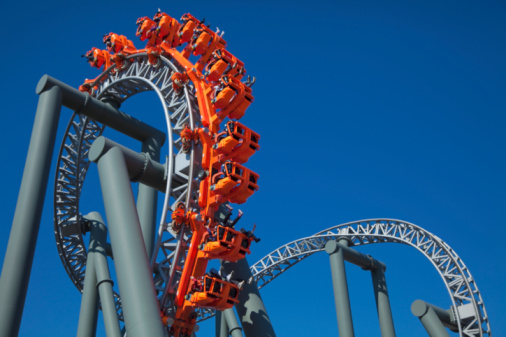 A rollercoaster doing a loop against a blue sky.