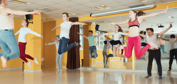 istock Tweens jumping with female coach in choreography class 967064178