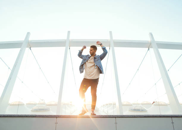 istock fashion guy sitting at sunset posing in sun glasses 967068984