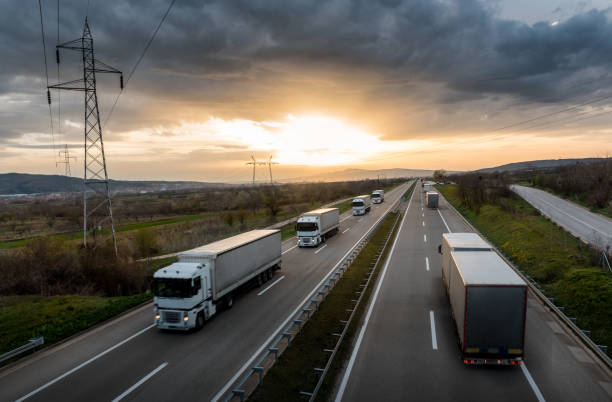 istock Caravan or convoy of white trucks on highway 967069520