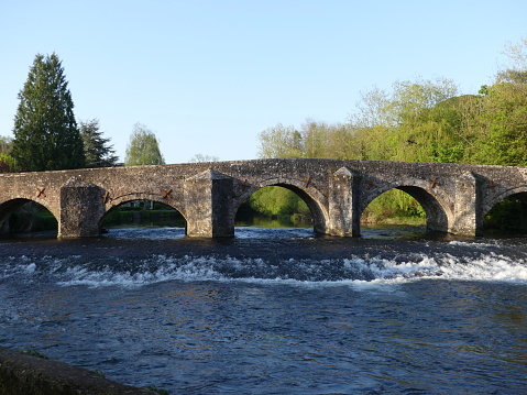 A Medieval stone bridge crossing the River Exe in Bickleigh village, Devon, England, UK on a summers day