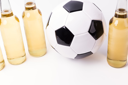Bottles of fresh beer with soccer ball on white background