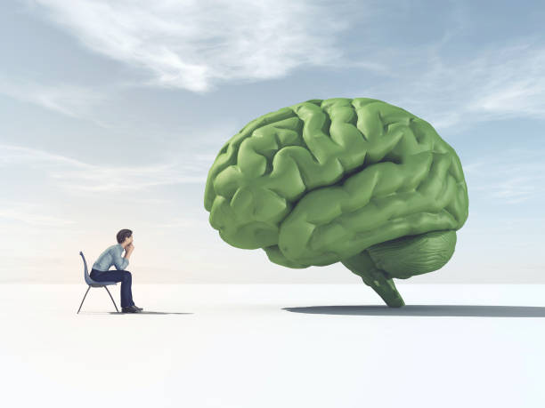 istock Man looking at a green brain in a field. 967086614
