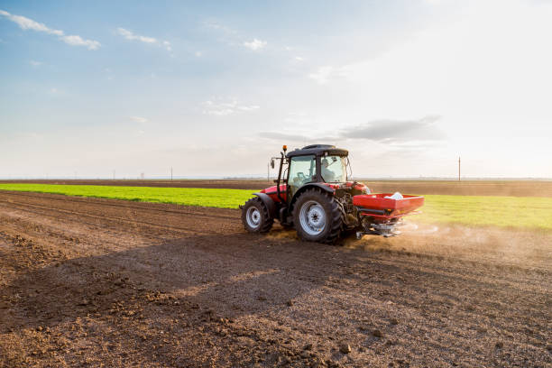 istock Farmer fertilizing arable land with nitrogen, phosphorus, potassium fertilizer 967091200