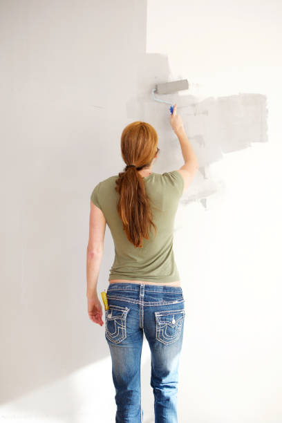 istock Mature woman painting wall 967104712