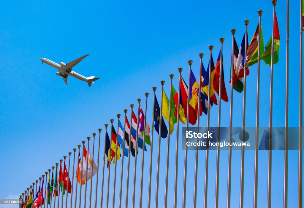 flags and airplane airplane flying over the national flags Country - Geographic Area Stock Photo