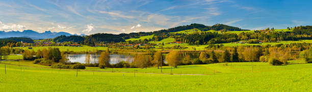 istock panoramic landscape in Bavaria with alps mountain range and lake 967105812