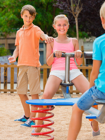 Children are teetering on the swing on the playground.