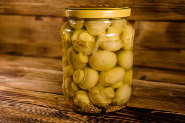istock Jar with canned mushrooms on wooden table 967113262