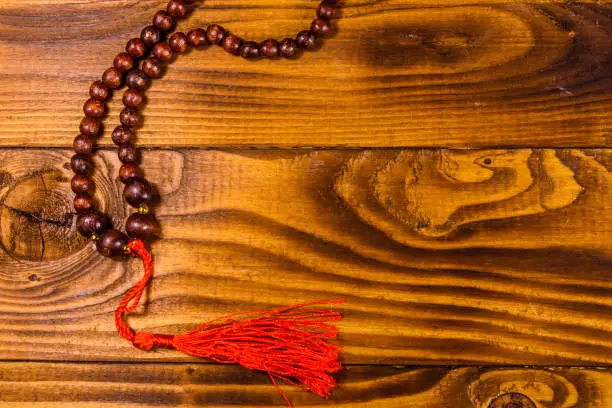 Photo of Brown rosary on the wooden table. Top view