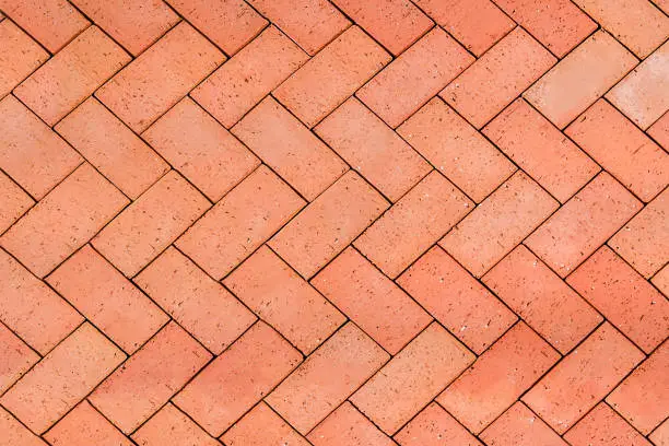 Photo of Red-Orange bricks tiled floor with zigzag pattern texture background