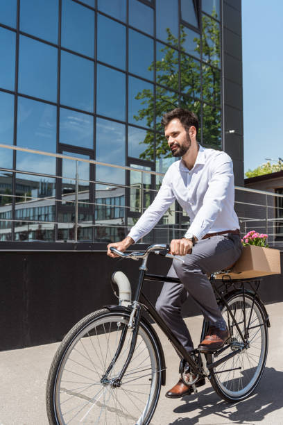 istock young happy manager riding on bicycle with box on trunk 967117778