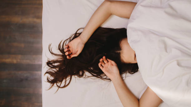 kobieta śpiąca na łóżku - lying in bed zdjęcia i obrazy z banku zdjęć