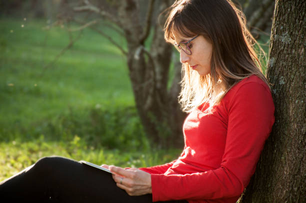 istock woman reading outdoors 967125548