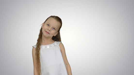 Happy beautiful little girl posing to a camera on white background. Close up. Professional shot in 4K resolution. 095. You can use it e.g. in your commercial video, business, presentation, broadcast video.
