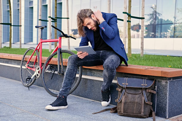 istock A man holds tablet PC with red single speed bicycle on background. 967134194