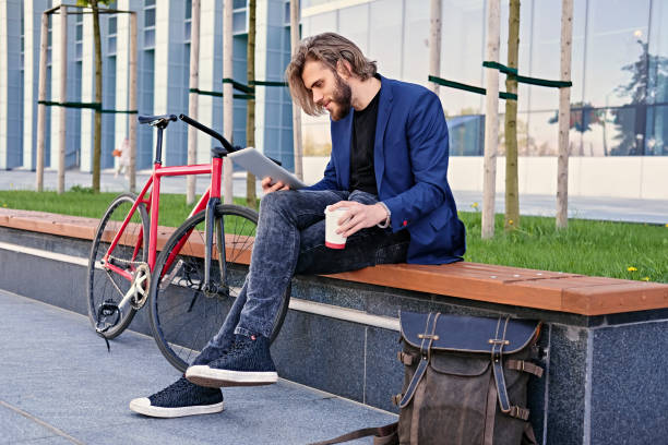 istock A man holds tablet PC with red single speed bicycle on background. 967134746