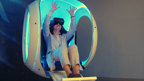 istock Emotional woman experiencing virtual reality in a moving interactive chair 967135034
