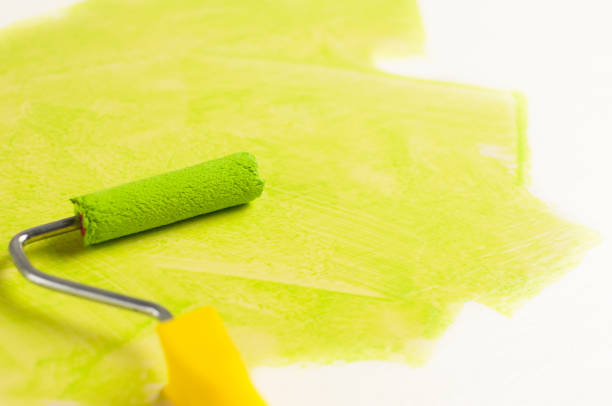 istock Roll for paint and green track on white wall. Repair concept 967142348