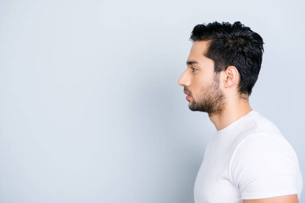 Young handsome man wearing casual white t-shirt over isolated background smiling looking side and staring away thinking.