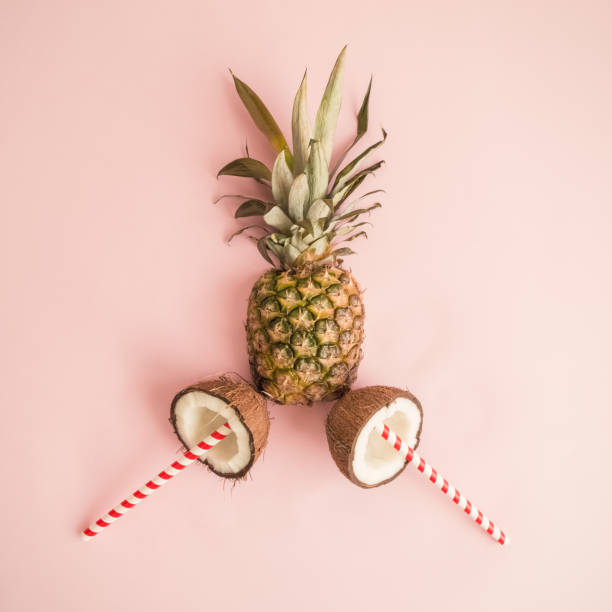 istock Flat lay of pineapple and coconut against rose background abstract. 967190292